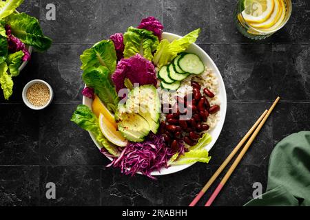 Avocado vegano insalata verde fresca con fagioli rossi, riso, cavolo napa rosso e cinese, cibo dietetico sano, vista dall'alto Foto Stock