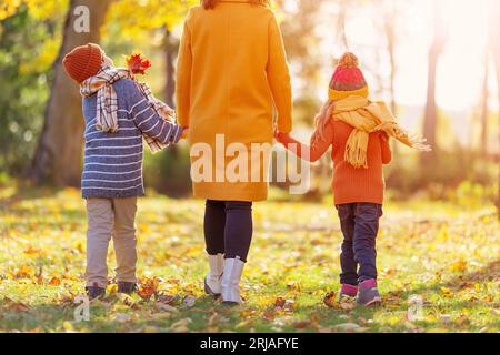 Madre con figlio e bimbo che cammina nel parco autunnale. Foto Stock