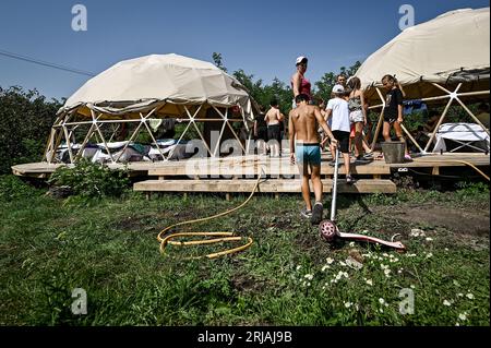 ZAPORIZHZHIA REGIONE, UCRAINA - 21 AGOSTO 2023 - i bambini soggiornano in tende dotate di letti elettrici per ricaricare gadget e giochi da tavolo Foto Stock