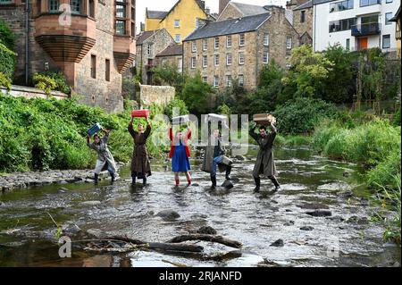 Edimburgo, Scozia, Regno Unito. 22 agosto 2023. Edinburgh Fringe: Home, lo spettacolo mette in evidenza la crisi climatica e come le inondazioni stanno colpendo i Fens nell'East Anglia. Cast di membri con oggetti di scena in The Water of Leith al Dean Village. Spettacolo al Pleasance Courtyard. Didascalia creata in parte dal comunicato stampa ufficiale. Credit Craig Brown/Alamy Live News Foto Stock