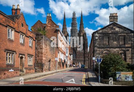 Una vista su una strada chiamata The Close verso la cattedrale gotica di Lichfield a Lichfield, Staffordshire, Regno Unito. L'enorme guglia centrale della cattedrale è di circa Foto Stock