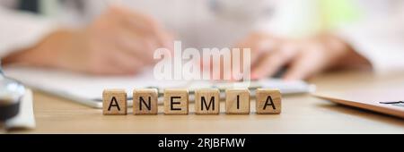 Iscrizione ANEMIA su cubi di legno e medico di controllo esami medici in background. Foto Stock