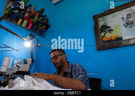 Gaza City, Palestina. 22 agosto 2023. Un sarto palestinese prepara vestiti per gli studenti di una scuola in una fabbrica di cucito nel campo profughi Shati a Gaza City, il 22 agosto 2023. Foto di Ramez Habboub/ABACAPRESS.COM credito: Abaca Press/Alamy Live News Foto Stock