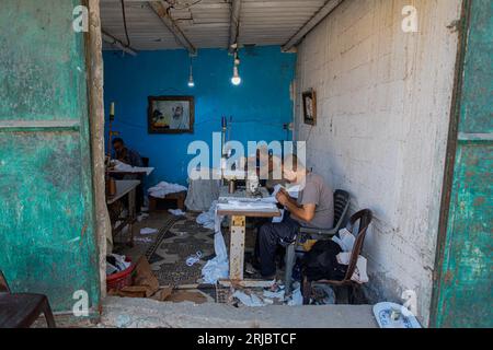 Gaza City, Palestina. 22 agosto 2023. Un sarto palestinese prepara vestiti per gli studenti di una scuola in una fabbrica di cucito nel campo profughi Shati a Gaza City, il 22 agosto 2023. Foto di Ramez Habboub/ABACAPRESS.COM credito: Abaca Press/Alamy Live News Foto Stock