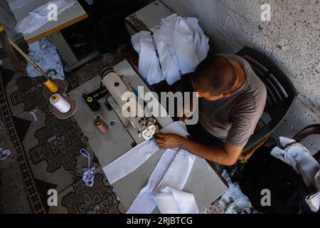 Gaza City, Palestina. 22 agosto 2023. Un sarto palestinese prepara vestiti per gli studenti di una scuola in una fabbrica di cucito nel campo profughi Shati a Gaza City, il 22 agosto 2023. Foto di Ramez Habboub/ABACAPRESS.COM credito: Abaca Press/Alamy Live News Foto Stock