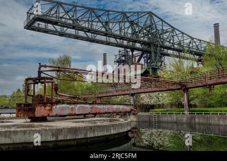 Vista ad angolo basso di un bacino di purificazione dell'acqua abbandonato e fatiscente di un'acciaieria industriale in Landschaftspark, Duisburg, Germania con Foto Stock