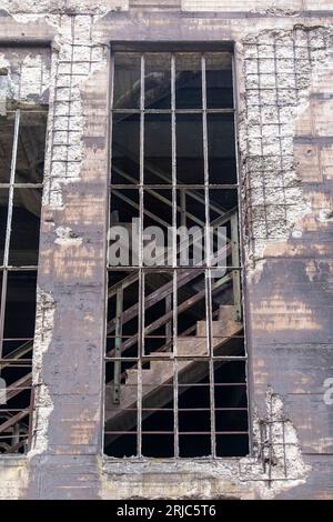 Vista angolare bassa della facciata di un edificio in acciaieria industriale abbandonata e fatiscente in Landschaftspark, Duisburg, Germania, con grande ungl Foto Stock
