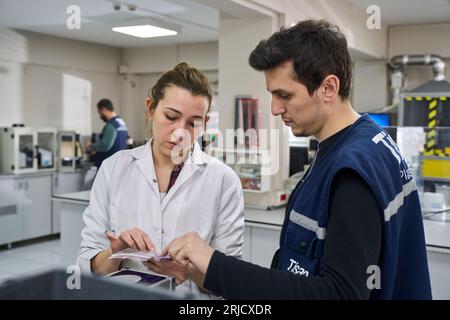 Persone che lavorano nel laboratorio di una fabbrica moderna. esame della qualità della plastica prodotta in fabbrica. esame della qualità dei granuli di plastica Foto Stock