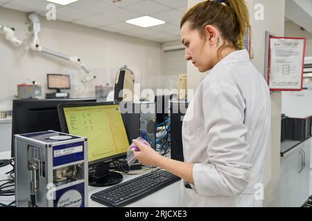 Persone che lavorano nel laboratorio di una fabbrica moderna. esame della qualità della plastica prodotta in fabbrica. esame della qualità dei granuli di plastica Foto Stock