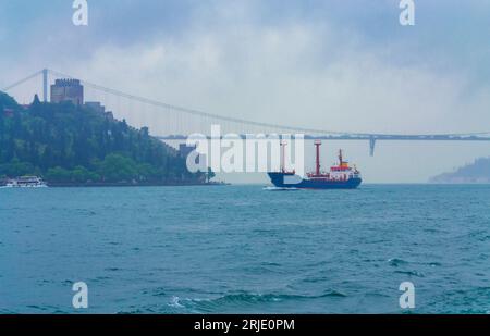 Stanbul, Turchia, 10 maggio 2014: Splendidi edifici sulla riva dello stretto del Bosforo nella città di Istanbul e barche da crociera che navigano nelle piogge giornate primaverili Foto Stock