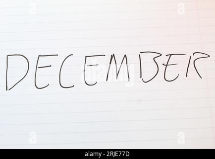 Una foto del mese di dicembre scritta su una pagina con righe bianche. Foto Stock