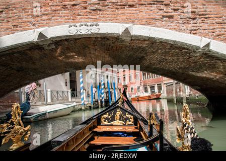 Gondola sotto un ponte a Venezia, Italia Foto Stock