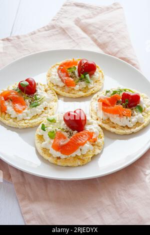 Torta di mais con formaggio cremoso, salmone e pomodori ciliegini a forma di cuore Foto Stock