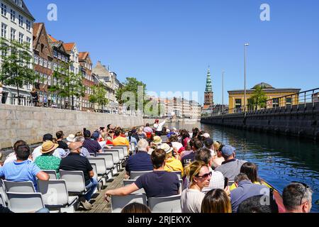 Copenaghen, Danimarca - 30 maggio 2023: Crociera turistica in barca con vista sul canale per gli edifici storici della città e l'argine Foto Stock