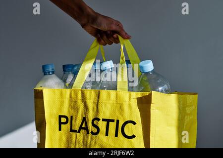 Attivista anonimo che mostra una borsa ecologica con bottiglie di plastica raccolte per il riciclaggio e il riutilizzo Foto Stock