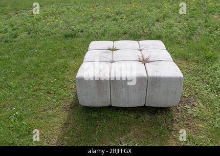 Panchine in pietra in un parco pubblico sotto forma di divani bianchi o ottomani per sedersi Foto Stock