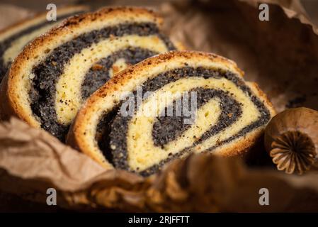 Frammenti di strudel fresco fatto in casa con semi di papavero su carta, vista dall'alto Foto Stock