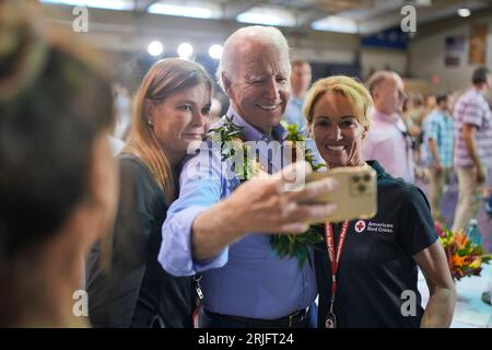 Lahaina, Stati Uniti. 21 agosto 2023. Il presidente degli Stati Uniti Joe Biden, Center, scatta un selfie con i residenti durante una riunione della comunità in seguito a incendi che hanno travolto la Maui occidentale al Lahaina Civic Center, 21 agosto 2023 a Lahaina, Maui, Hawaii. Credito: Adam Schultz/White House Photo/Alamy Live News Foto Stock