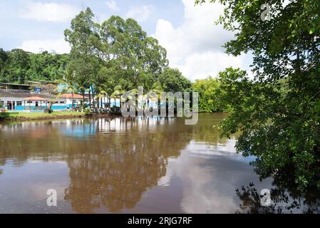 Valenca, Bahia, Brasile - 10 gennaio 2023: Vista del fiume una circondata da piante, alberi ed edifici commerciali. Città turistica di Valenca nel Foto Stock