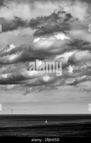 Yacht singolo da solo contro il mare e il cielo tempestosi con cumulus nimbus pronto a scendere Foto Stock