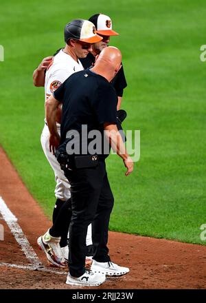 Baltimora, Stati Uniti. 22 agosto 2023. James McCann dei Baltimore Orioles è assistito dopo essere stato colpito da un lancio del lanciatore di rilievo dei Toronto Blue Jays Yimi Garcia durante il quinto inning a Camden Yards a Baltimora, MD, martedì 22 agosto 2023. Foto di David Tulis/UPI credito: UPI/Alamy Live News Foto Stock