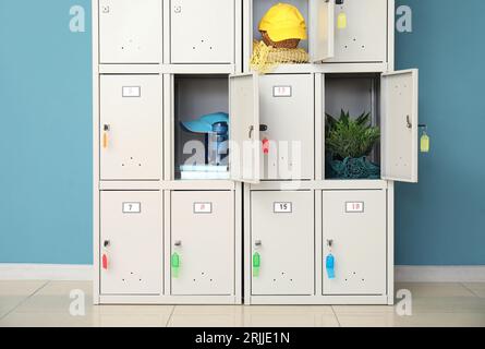 Armadietto moderno con oggetti vicino al muro blu Foto Stock
