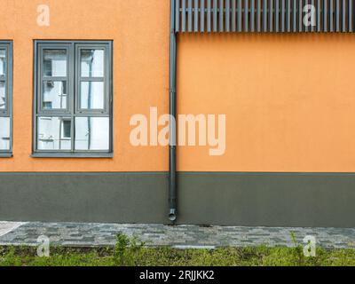 vecchio edificio industriale dopo la ristrutturazione. finestre su parete in stucco arancione. Foto Stock