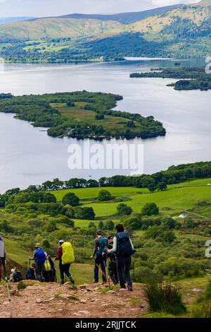 Escursionisti e escursionisti che scendono da Conic Hill con vista su Balmaha e Loch Lomond nelle Highlands scozzesi. Foto Stock