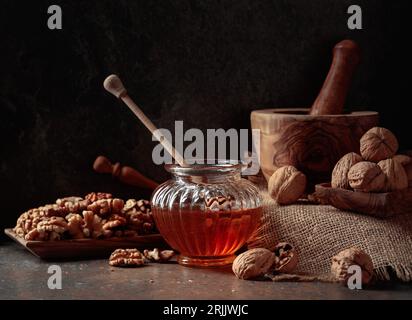 Miele e noci su un vecchio tavolo da cucina. Foto Stock