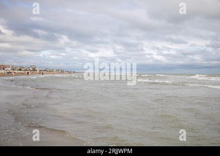 Rimini, Italia - 5 agosto 2023 Vista della spiaggia in una giornata nuvolosa nella stagione estiva. Foto Stock