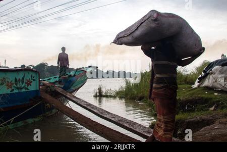 Le bucce di legno sono scaricate dalla barca. Questa foto è stata scattata il 14 settembre 2022, da Ruhitpur, Bangladesh Foto Stock