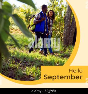 Composito di testo ciao settembre su coppia birazziale in giardino Foto Stock