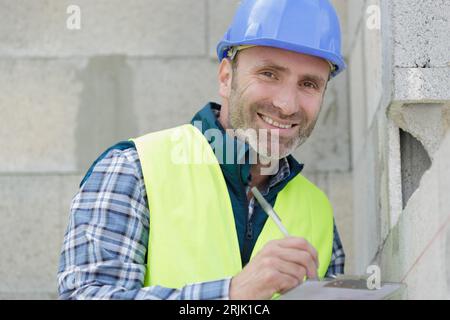 costruttore che prepara stima per miglioramento esterno domestico Foto Stock