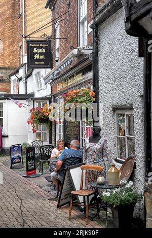 Caffè sul marciapiede UK con persone che mangiano all'aperto nella Market Square, Evesham Worcestershire, Inghilterra Foto Stock