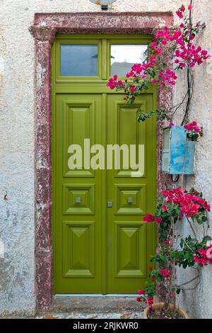 Bellissima porta verde in legno con bouganvillea di un'antica residenza nel villaggio di Pyrgos Kallistis, nell'isola di Santorini, Cicladi, Grecia Foto Stock