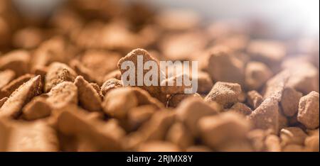 Instant freeze dried coffee on brown background. Structure of instant coffee. Stock Photo