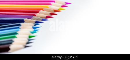 A row of colored pencils against a white background, designed to be used as border for page layout, with space for text. Foto Stock