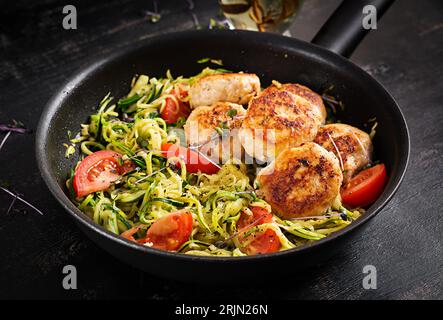 Spaghetti di zucchine con polpette di pollo in padella. Foto Stock