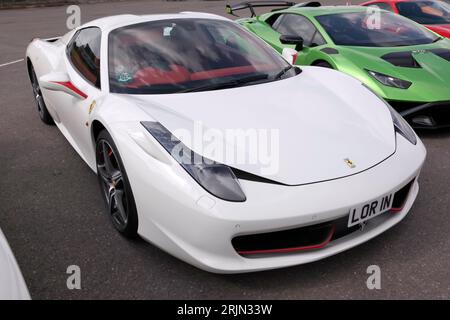 Vista frontale di tre quarti di una Ferrari 458 2012 bianca, esposta nel paddock delle supercar, al British Motor Show del 2023 Foto Stock