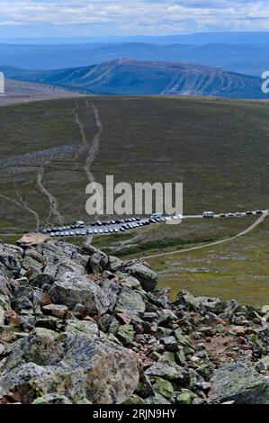 In mezzo alla natura scandinava mozzafiato, vista elevata dalla cima rocciosa della montagna o affioramento su auto parcheggiate, camper e camper, Svezia Foto Stock
