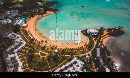 Una vista aerea panoramica di una spiaggia con palme verdi e hotel. Residence a Mauritius. Foto Stock