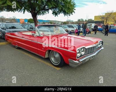 Vecchia Chevrolet rossa del 1964 Chevy Impala SS Super Sport V8 due porte convertibile GM in un parcheggio. Mostra di auto d'epoca Foto Stock