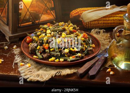 Braised beef with beans and corn on a wooden background Stock Photo