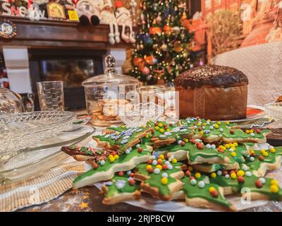 Un assortimento di biscotti freschi di Natale decorati con vibrante glassa verde e colorate creme di caramelle, ideali per un dolce natalizio Foto Stock