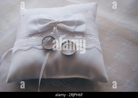 Wedding rings on a white pillow I Stock Photo
