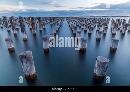 Un tranquillo paesaggio marino a Princes Pier, Melbourne, Australia, con un tranquillo oceano blu e uno splendido skyline sullo sfondo Foto Stock