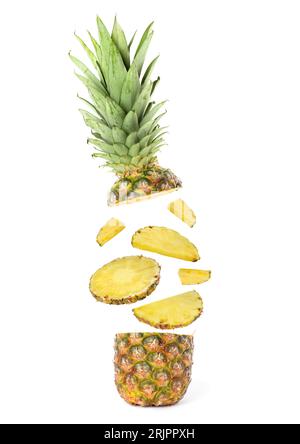 Fette di ananas succoso che volano tra la parte superiore e quella inferiore su sfondo bianco Foto Stock