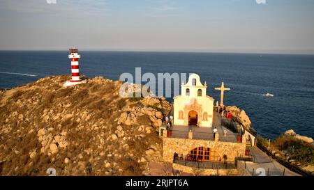 Una vista aerea di un paesaggio montano con un faro e attraversa la cima di una collina rocciosa Foto Stock