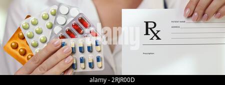 Il medico femminile mostra diverse pillole mediche e carta da prescrizione. Foto Stock