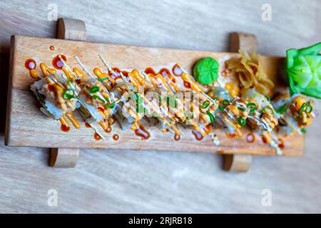 Primo piano di una selezione di involtini di verdure su un piatto di legno. Foto Stock